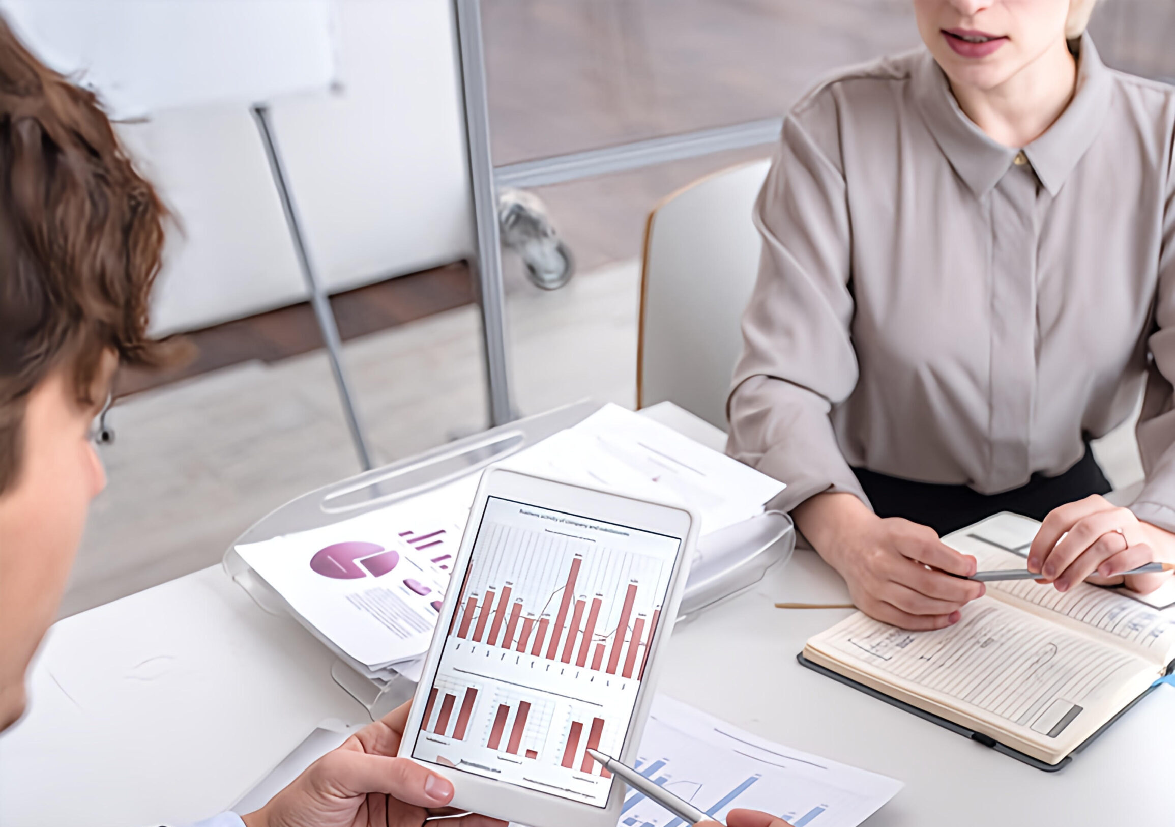 Two team members analyzing data on tablet